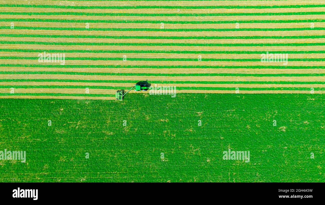 Above top view on tractor as pulling grass cutting machinery over field