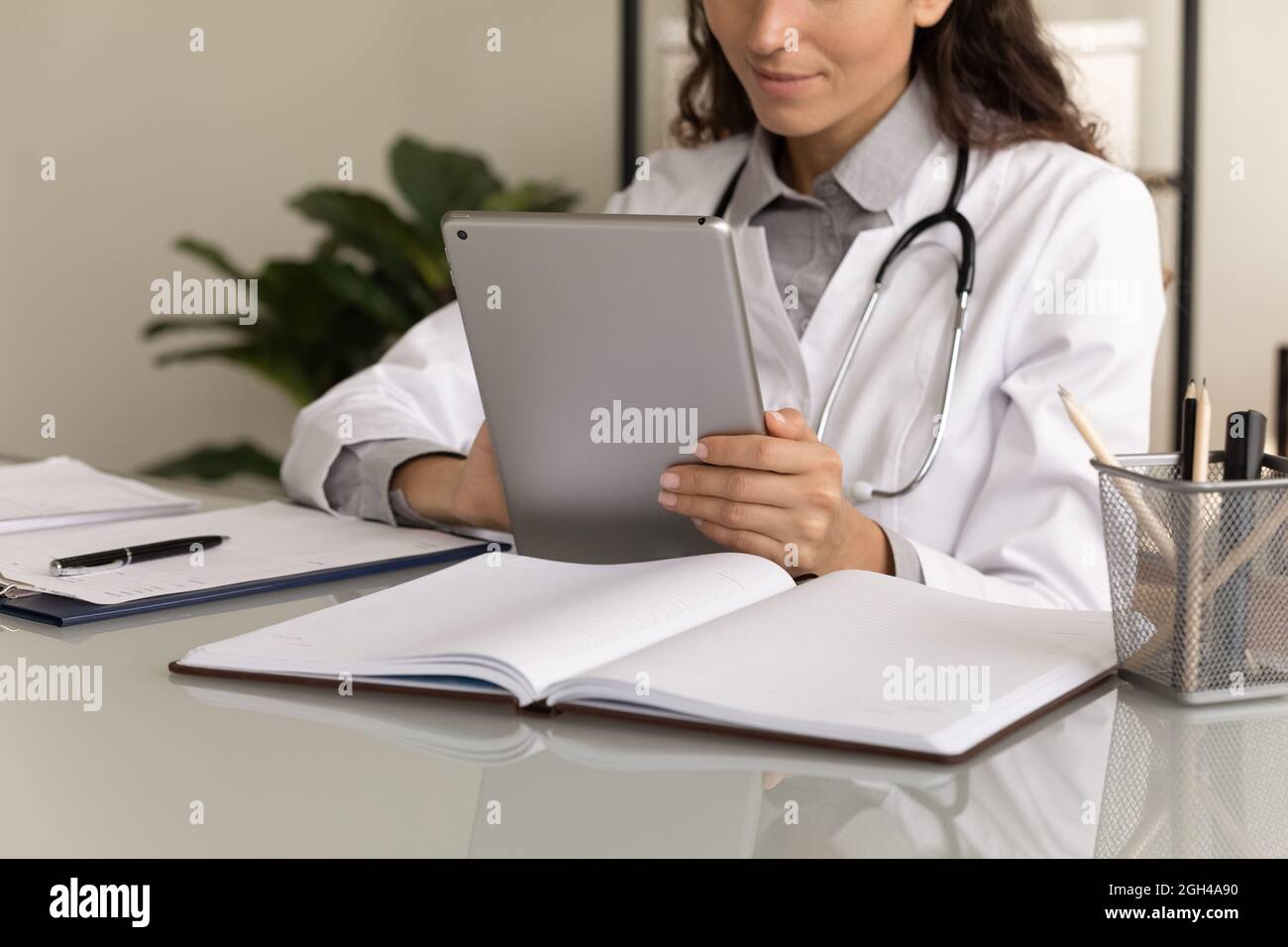 Female physician using tablet computer, giving online virtual consultation Stock Photo