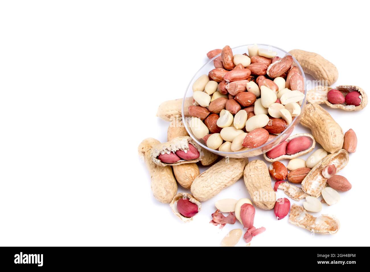 Peanut butter isolated and peanuts in the peel scattered on the white