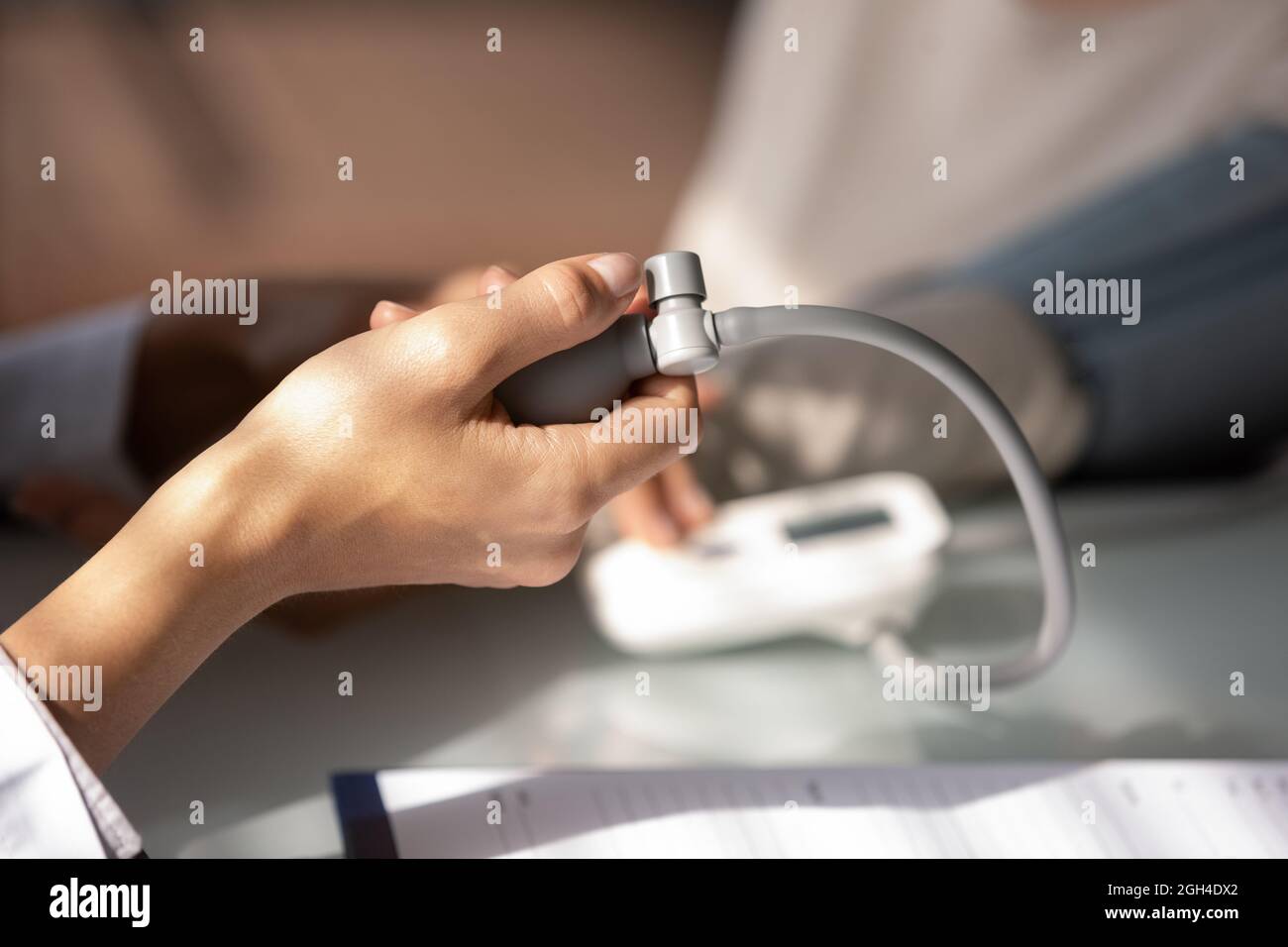 Hand of doctor using sphygmomanometer for checking blood pressure Stock Photo