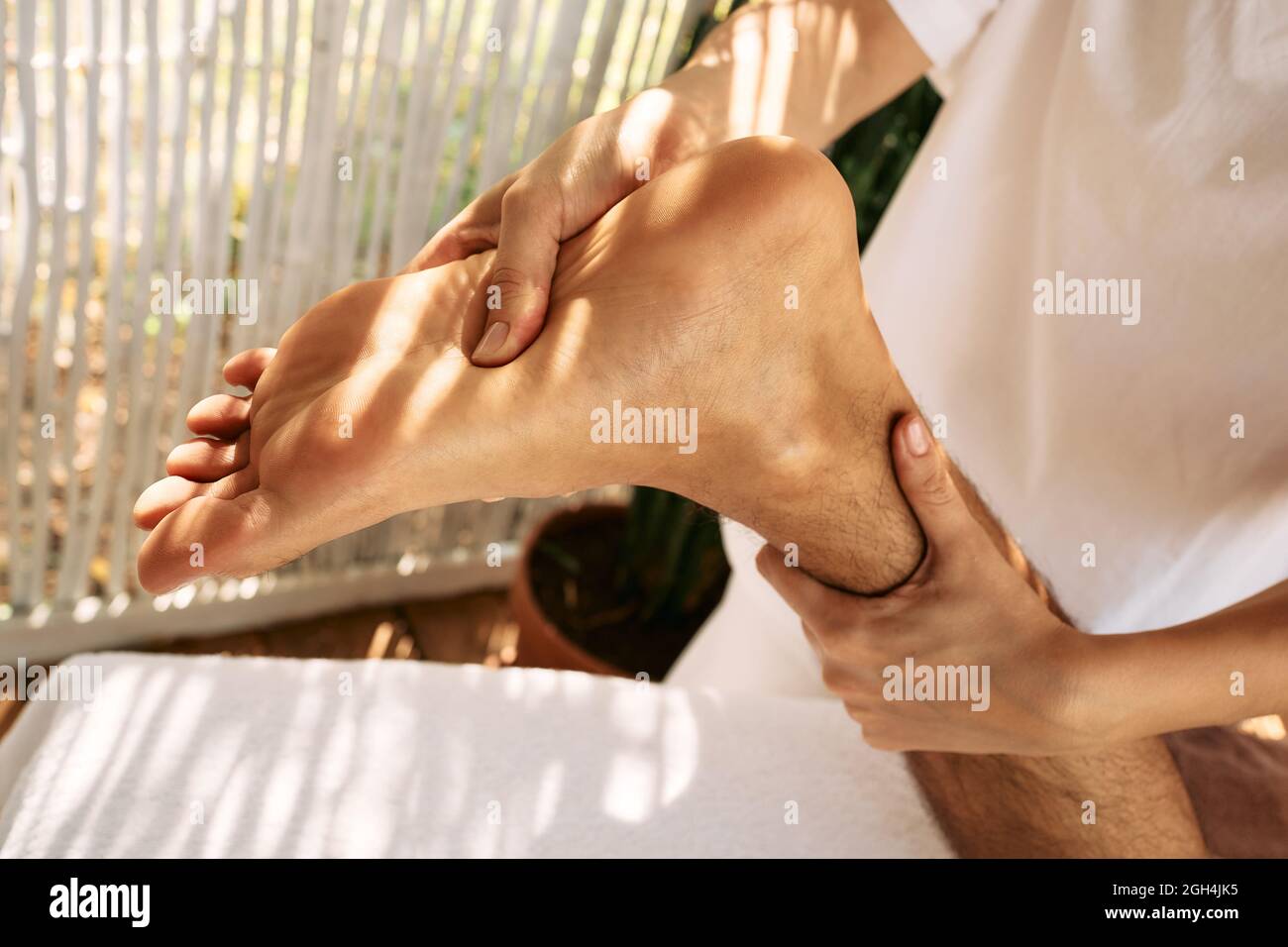 Foot massage with massage oil for man while relaxing and resting at spa on vacation Stock Photo