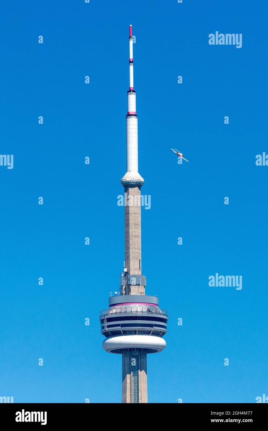A plane of The Canadian Forces (CF) Snowbirds, 431 Air Demonstration Squadron flies by the CN Tower during the Canadian International Air Show (CI Stock Photo