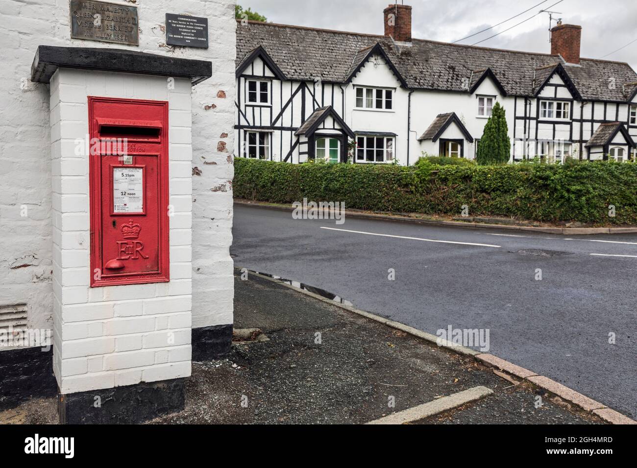 Post box in the village of Berriew near Montgomery, Powys, Wales. A plaque above the box commemorates a visit by the Queen in 1986. Stock Photo