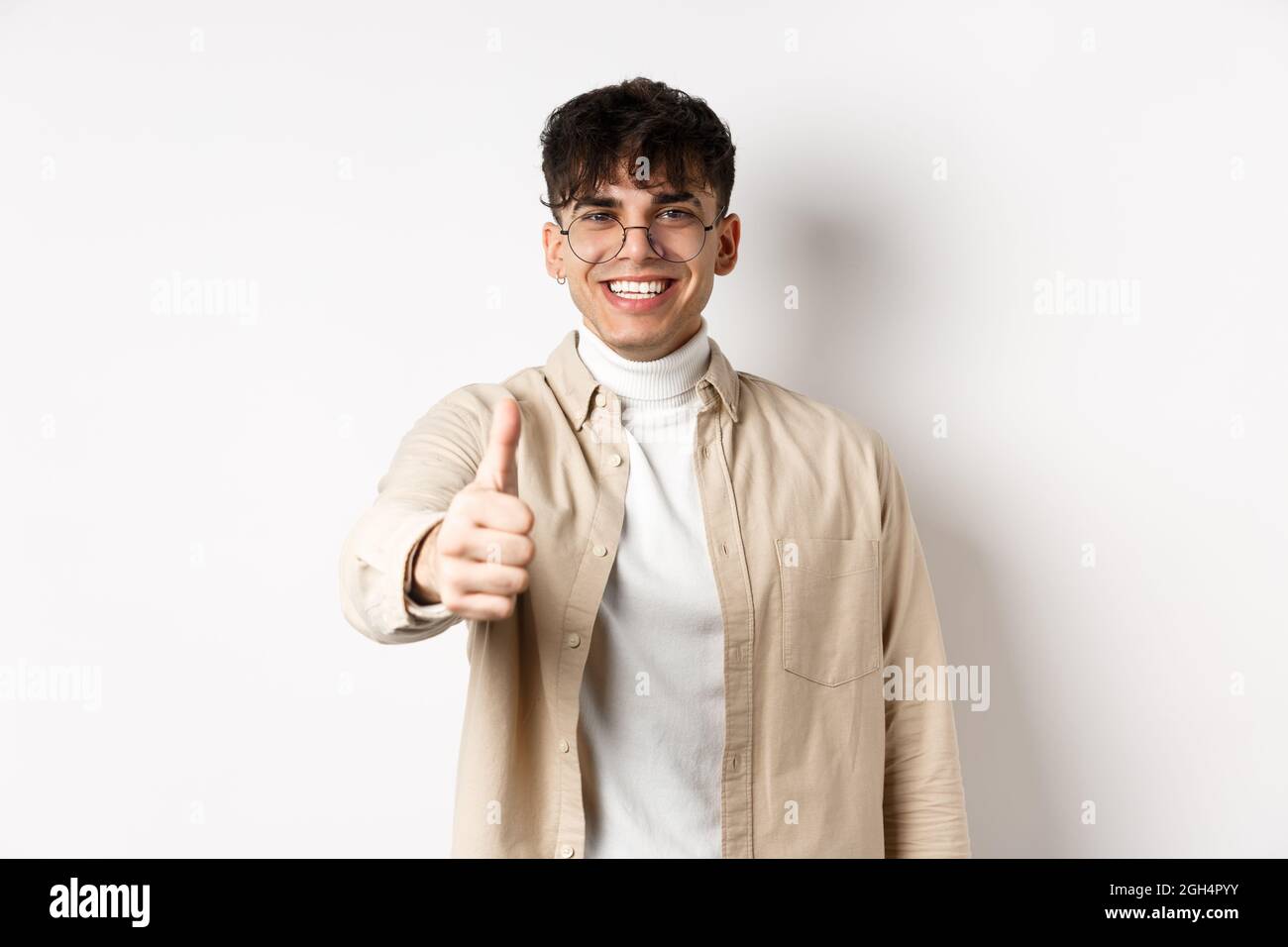 Image of happy young man showing thumb up and smiling satisfied, praise ...