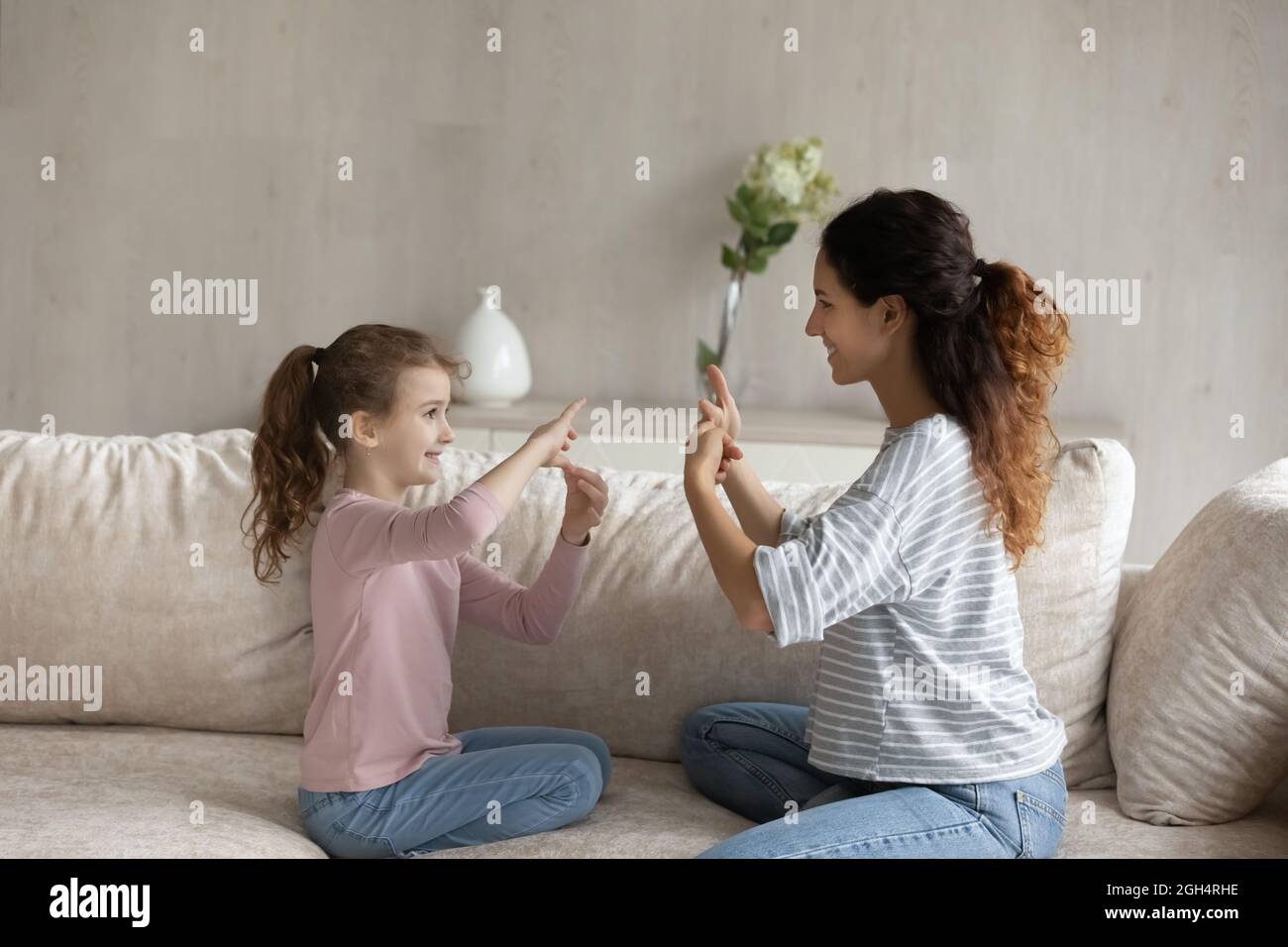 Adorable girl practicing communication with caring mum. Stock Photo