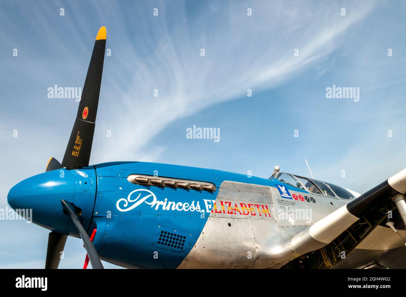 North American P-51 Mustang fighter plane named Princess Elizabeth. Blue nosed Second World War US fighter plane in blue sky with wispy clouds Stock Photo