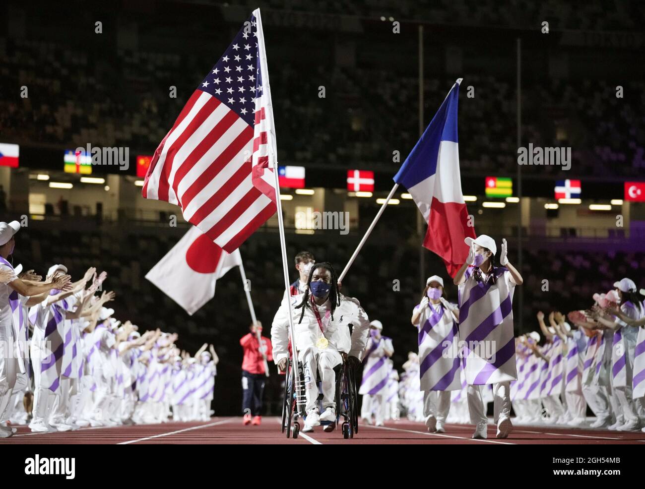 A U.S. flag bearer (front) parades during the closing ceremony of the Tokyo Paralympics on Sept