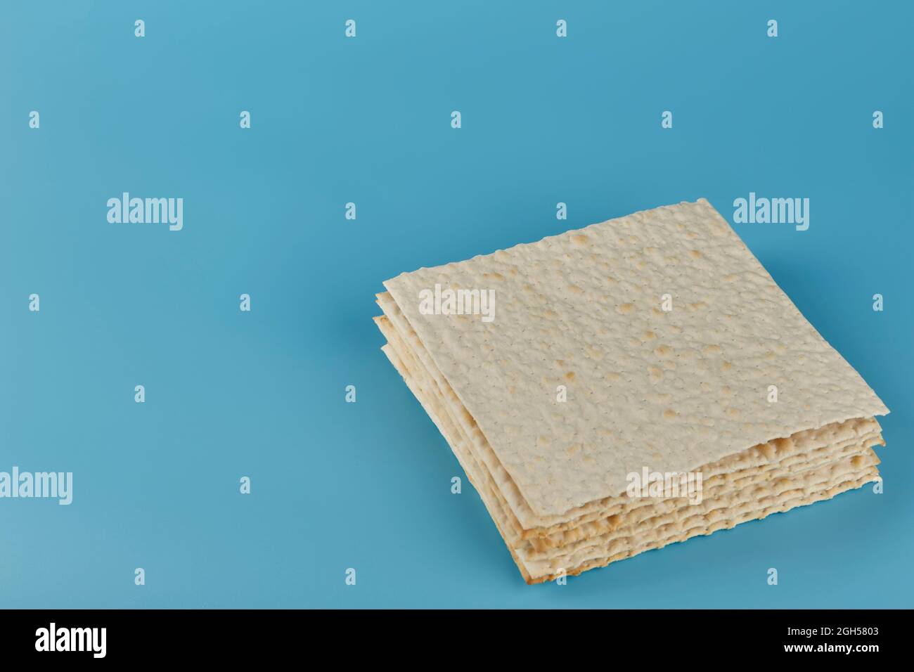 Traditional Jewish kosher matzo for the Passover holiday on a blue