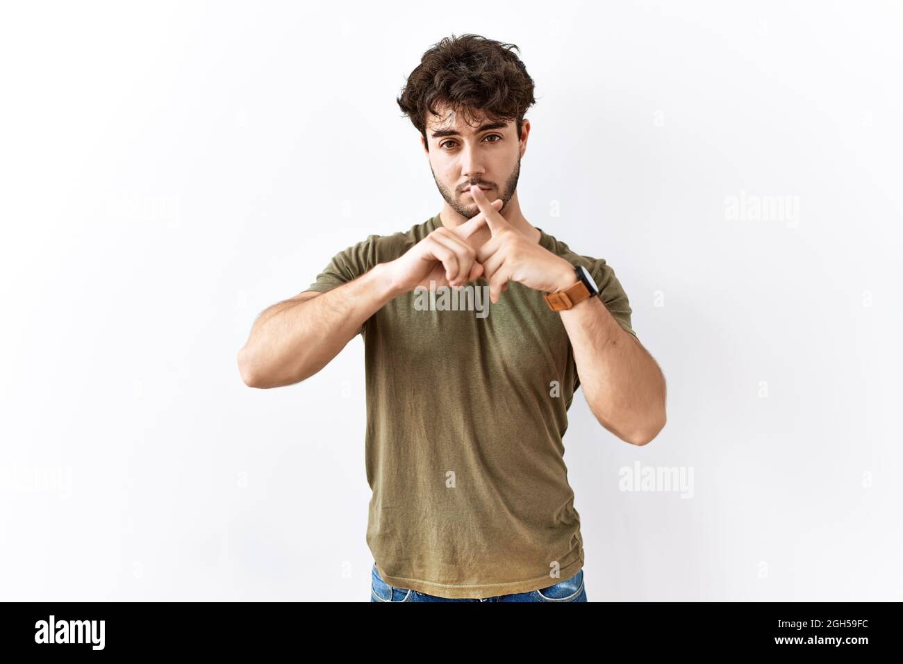 Hispanic man standing over isolated white background rejection ...