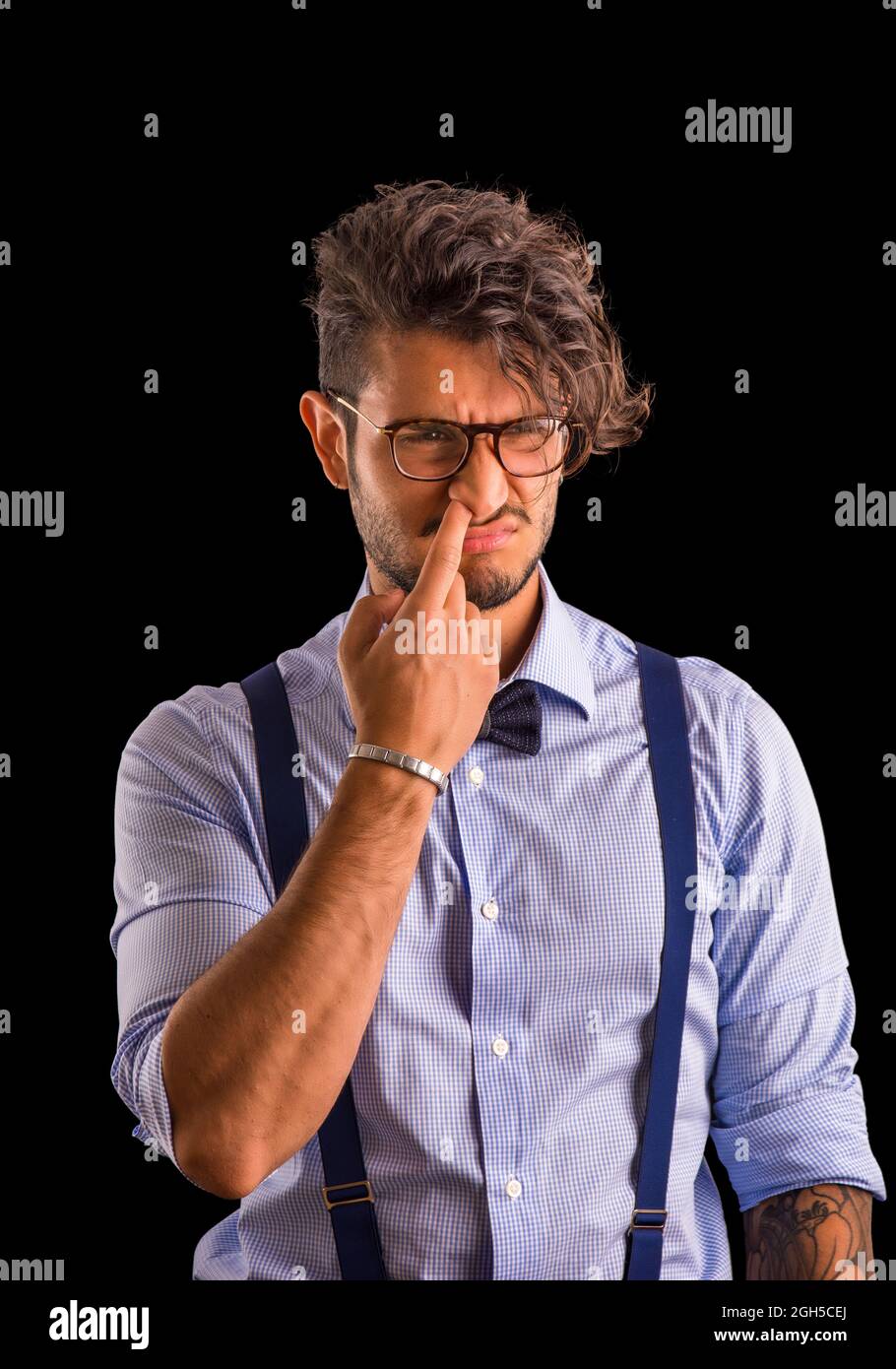 Stylish young man with a finger in his nose Stock Photo