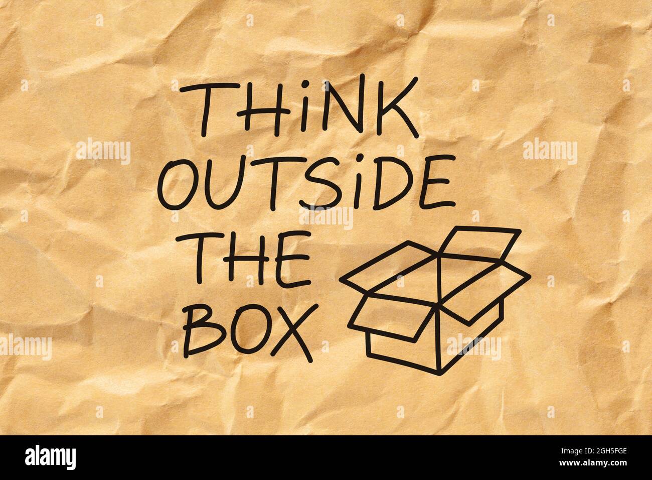Text Think Outside The Box handwritten on crumpled brown paper. Creativity or innovation concept. Stock Photo