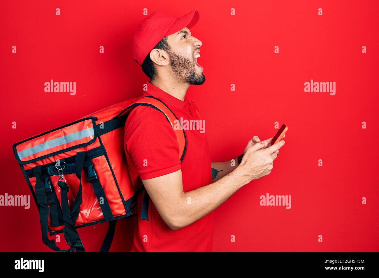 Hispanic man with beard wearing delivery package backpack using ...