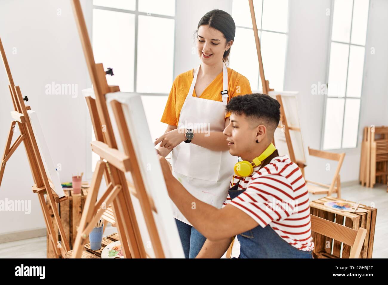 Student and teacher smiling happy painting at art school Stock Photo ...