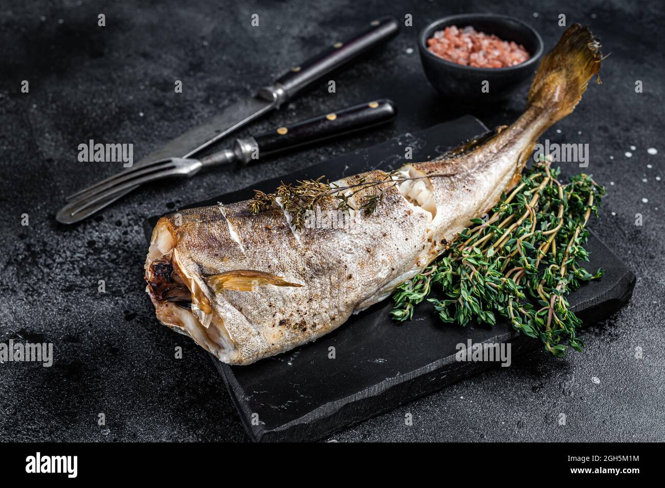 Roasted cod white fish with thyme on marble board. Black background ...