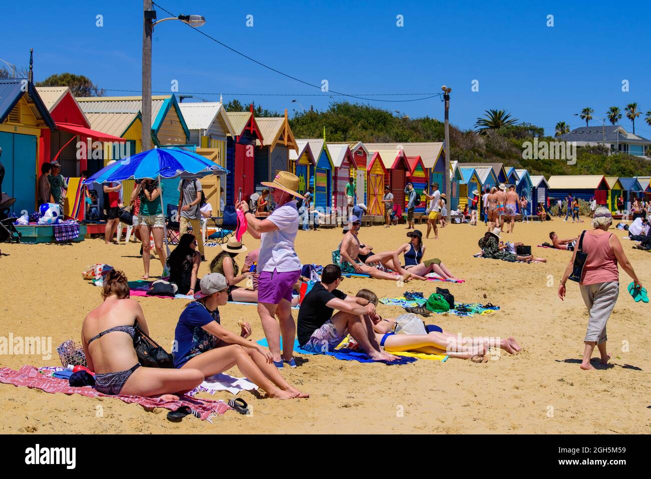 People having fun on the Brighton Beach with colorful Bathing Boxes as