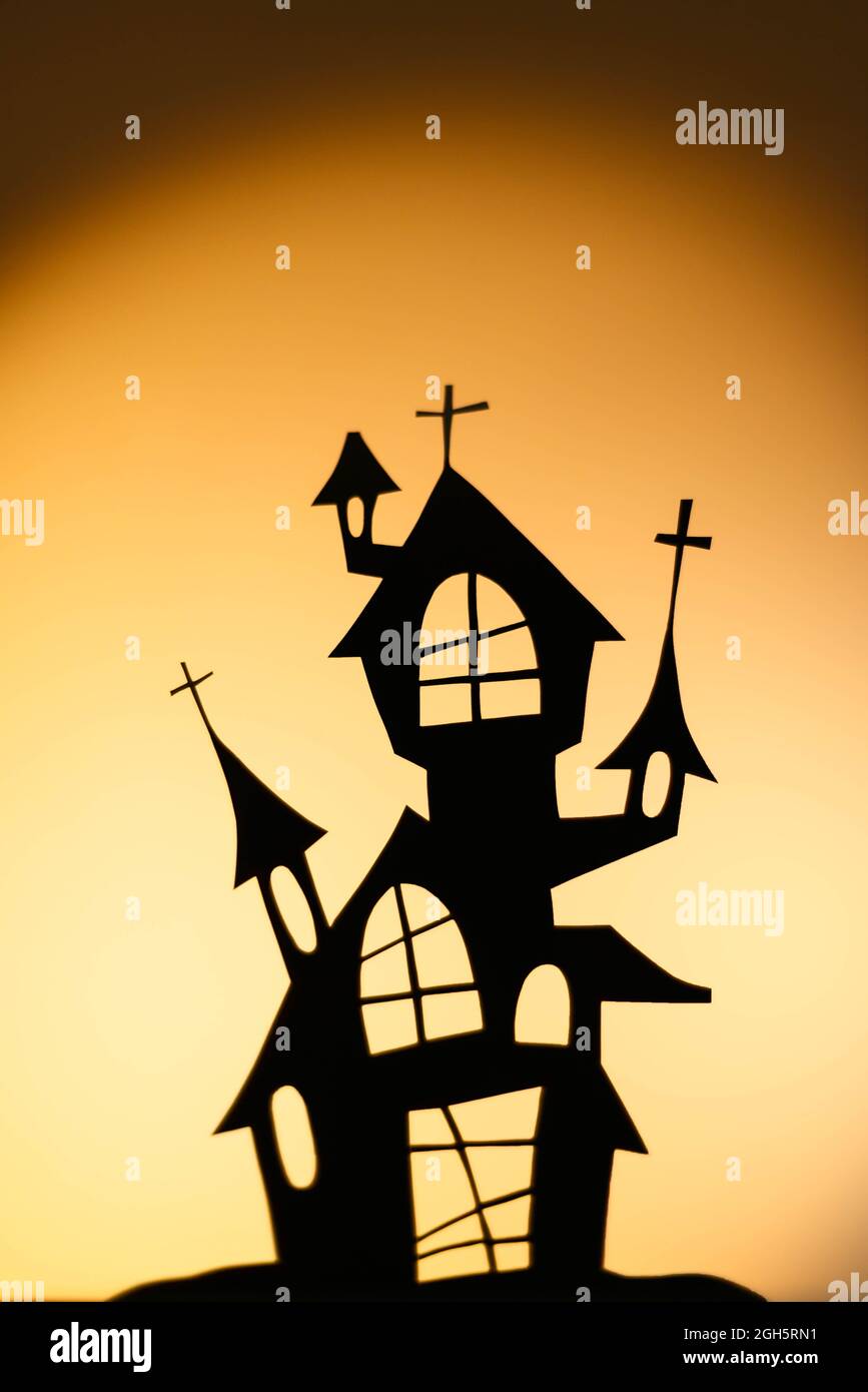 Silhouette of black puppet house casting on orange wall during Halloween celebration Stock Photo