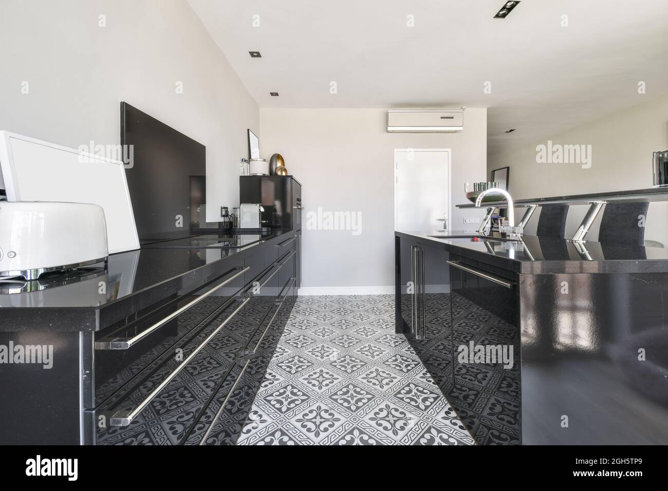 Modern home interior design of spacious open plan kitchen with black  furniture and ornamental tiles on floor and with large panoramic windows  overlook Stock Photo - Alamy