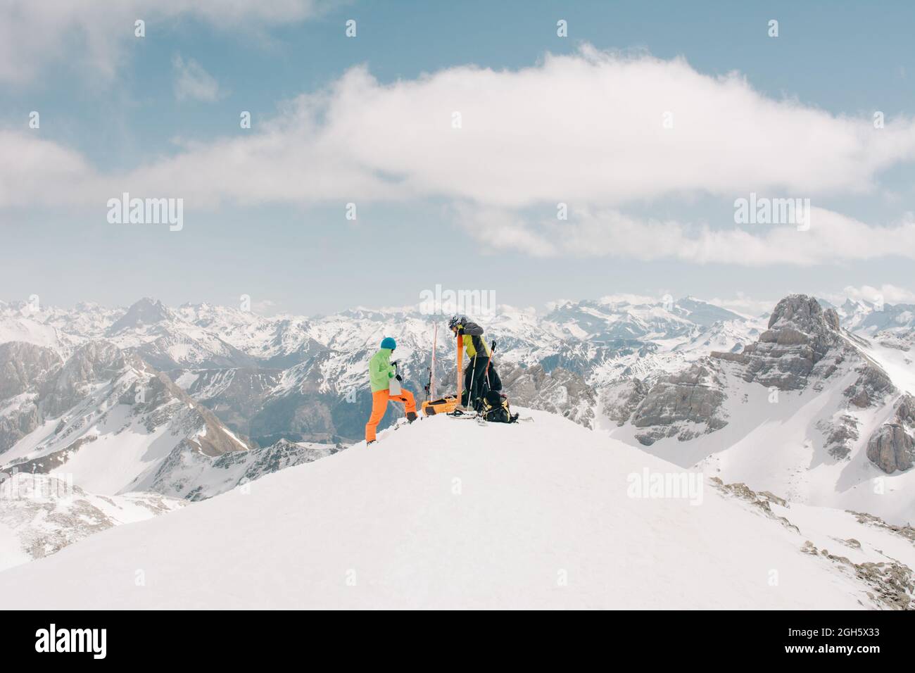 Side view of unrecognizable athletes talking on snow during trip on Pico Aunamendi in Pyrenees Mountains in Navarre Spain Stock Photo