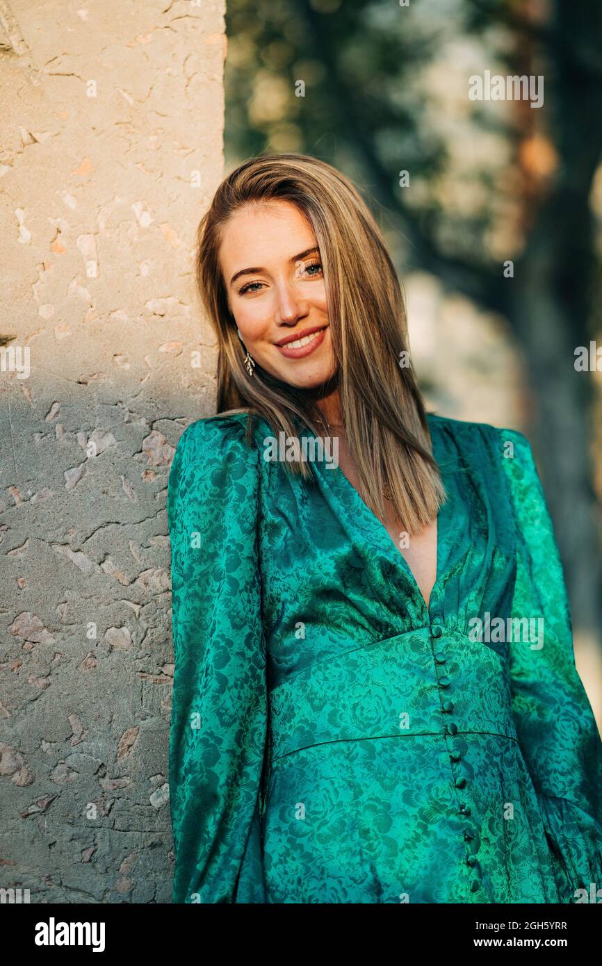 Elegant lady in hat and leather jacket shooting on camera and standing