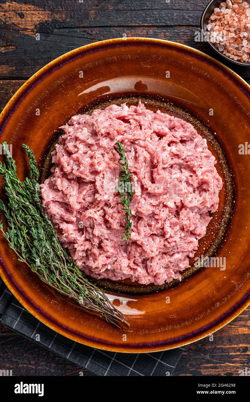 Ground chicken or turkey meat, raw Poultry on rustic plate with herbs