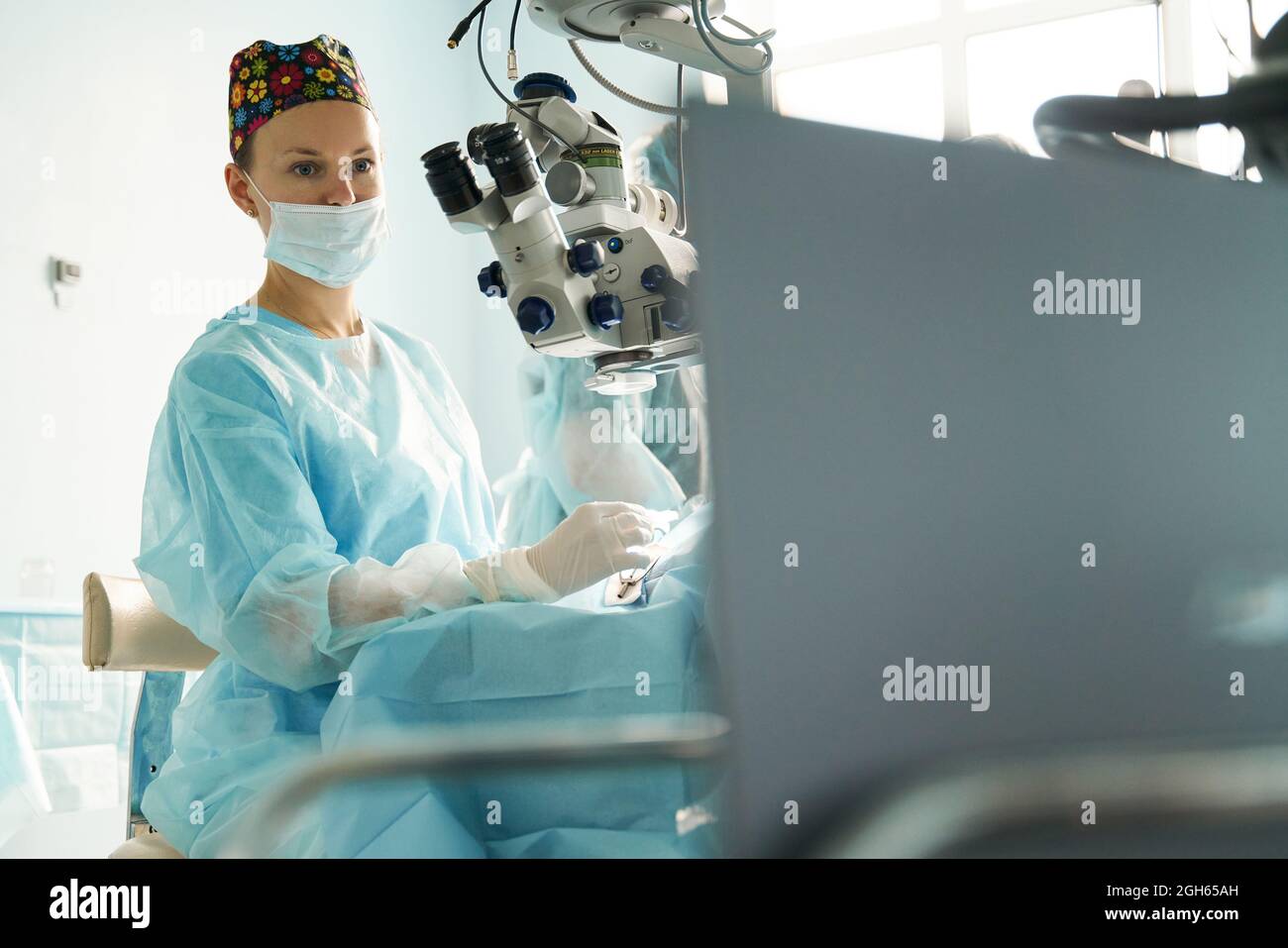 Attentive adult female medic in disposable mask and ornamental cap ...