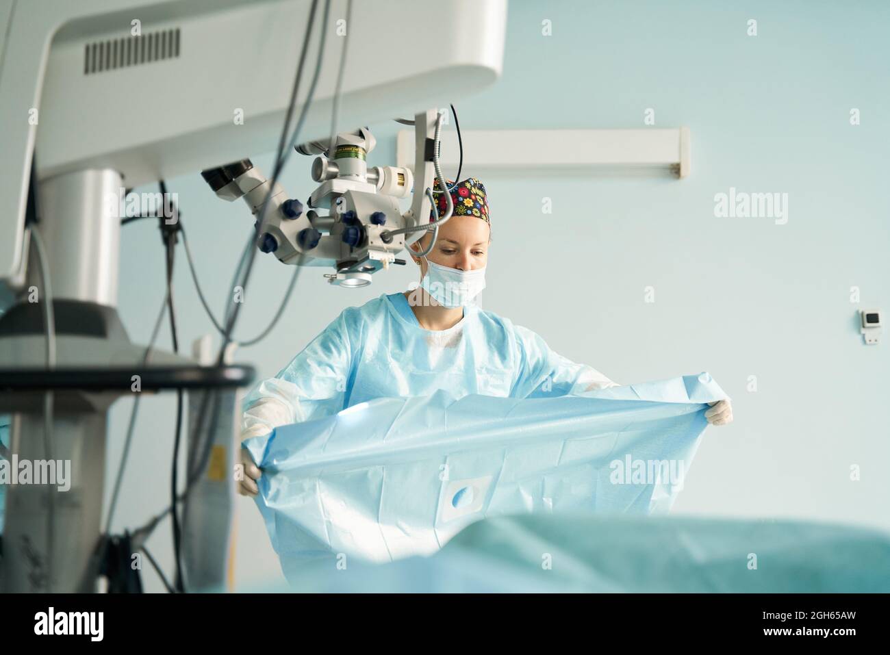 Attentive adult female medic in disposable mask and ornamental cap ...