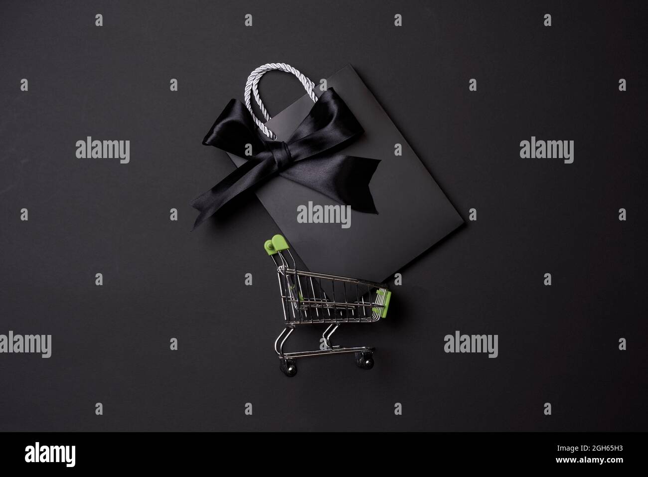 Black friday concept with shopping trolley on black background Stock Photo