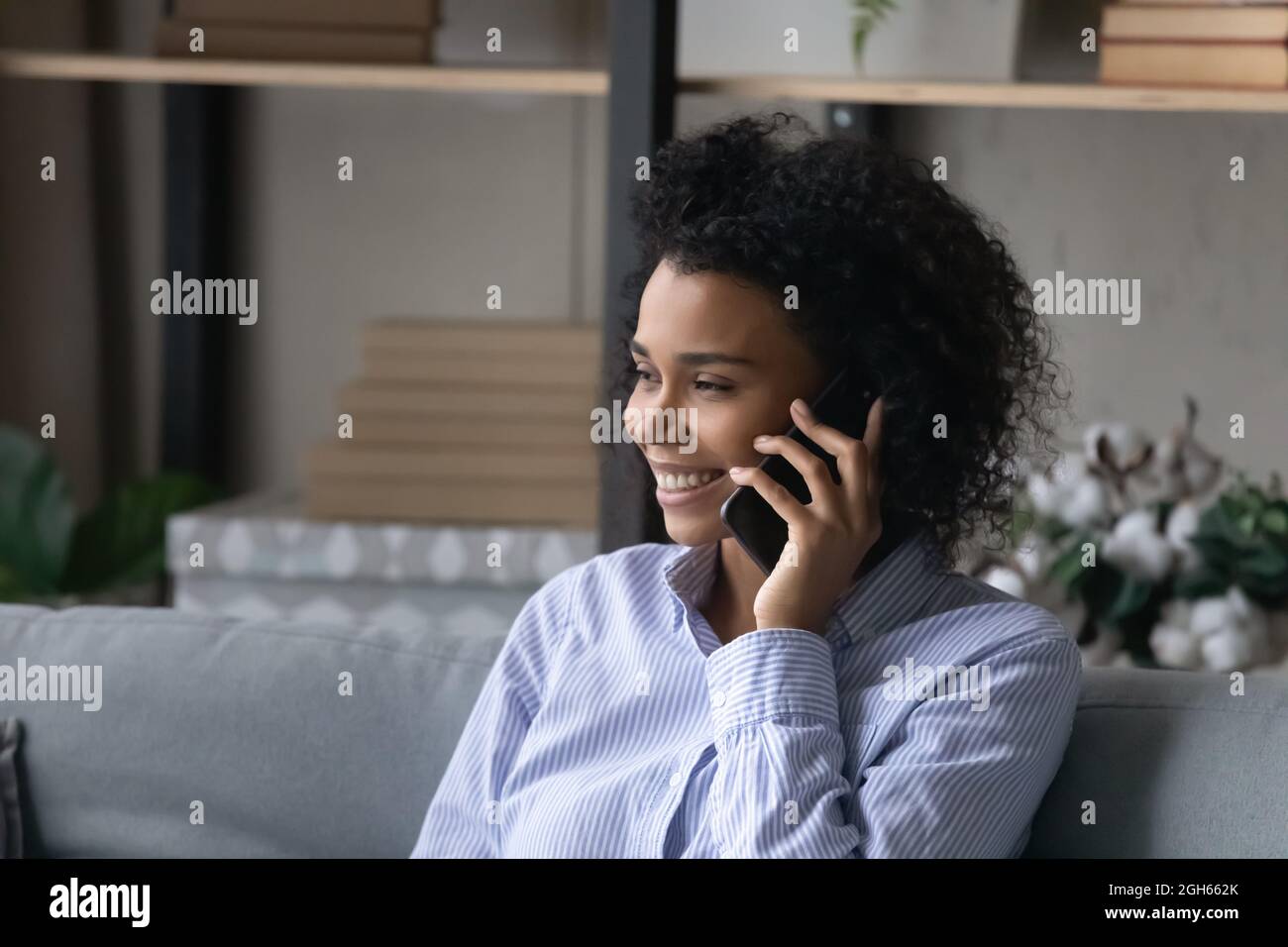 Smiling black millennial female realtor talk on cell advice customer Stock Photo