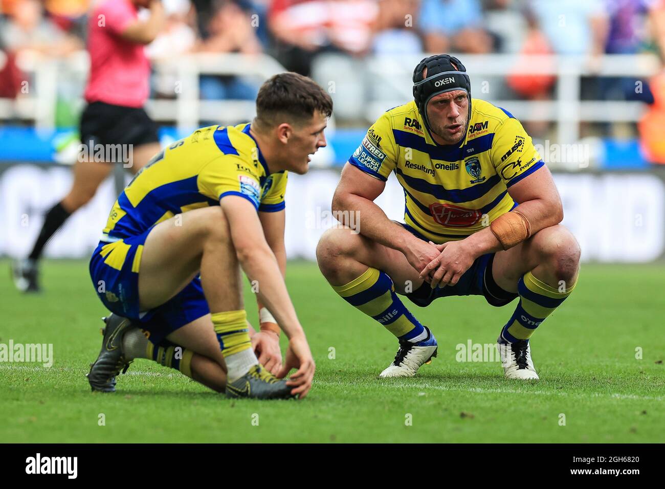 Chris Hill (8) of Warrington Wolves crouches down to catch his breath after the final whistle Stock Photo