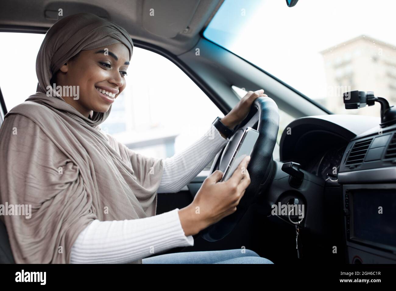 Driver behind steering wheel and device with map for traveling in transport in city Stock Photo