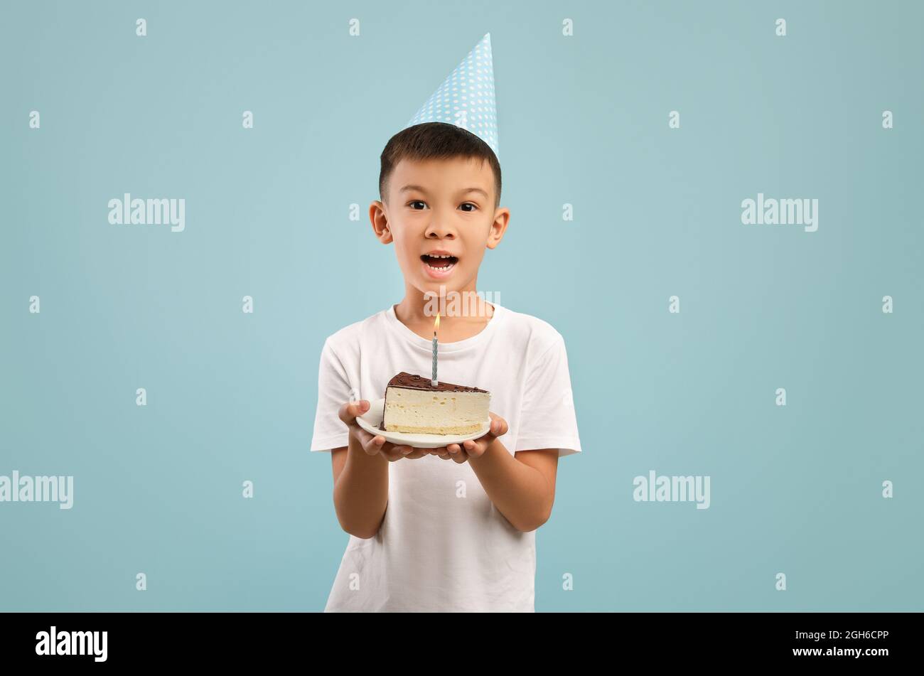 Happy Little Asian Boy In Party Hat Holding Birthday Cake With Candle Happy Little Asian Boy In Party Hat Holding Birthday Cake With Candle