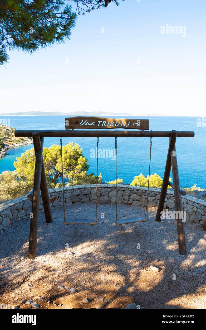 Tribunj, Croatia - August 6, 2021: Viewpoint terrace on a promenade on the hill by the sea with the double swing and a beautiful view point Stock Photo