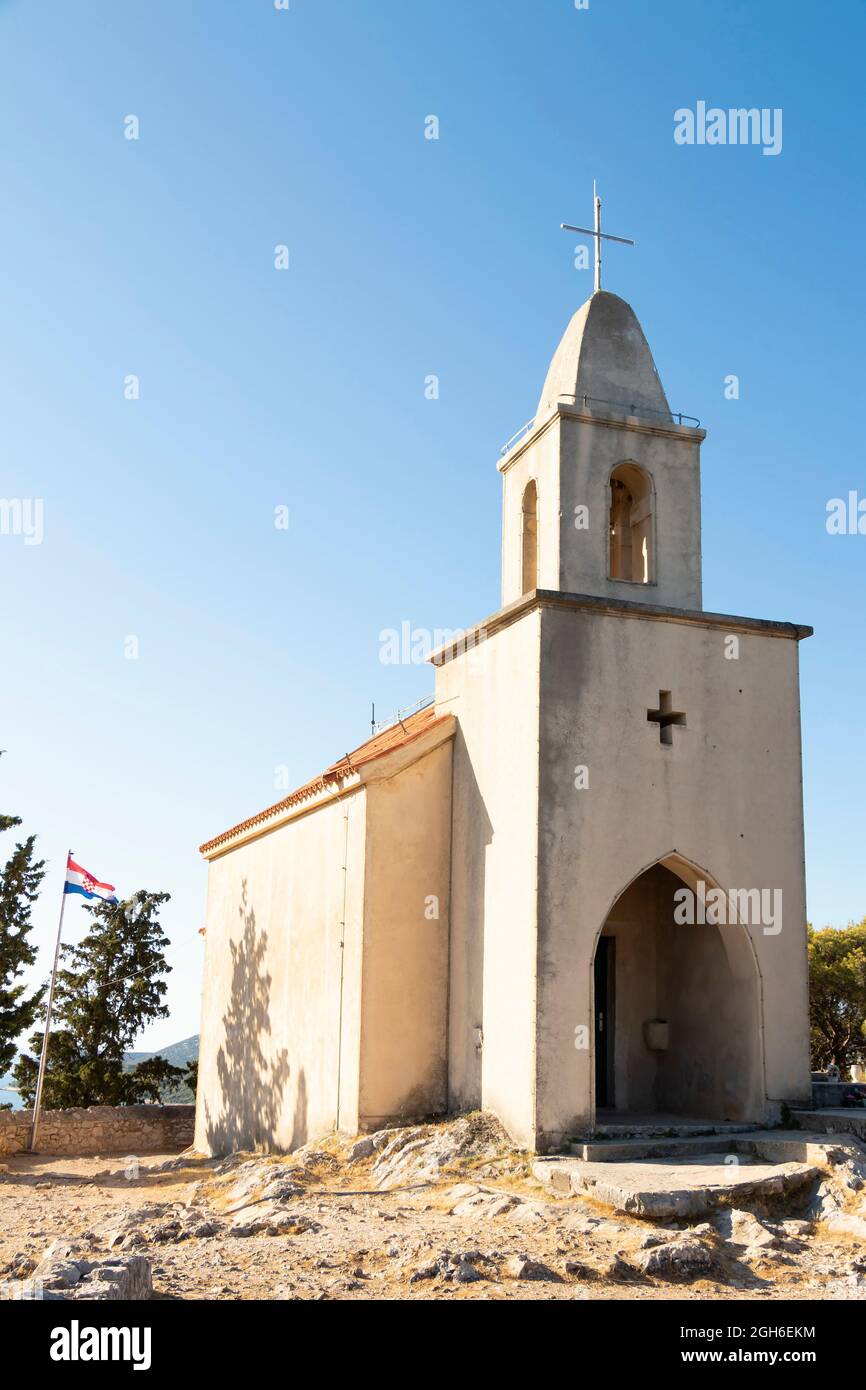Tribunj, Croatia - August 6, 2021: Church of St Nicholas, from the 15th century, at the old cemetery located on a hill of the same name Stock Photo