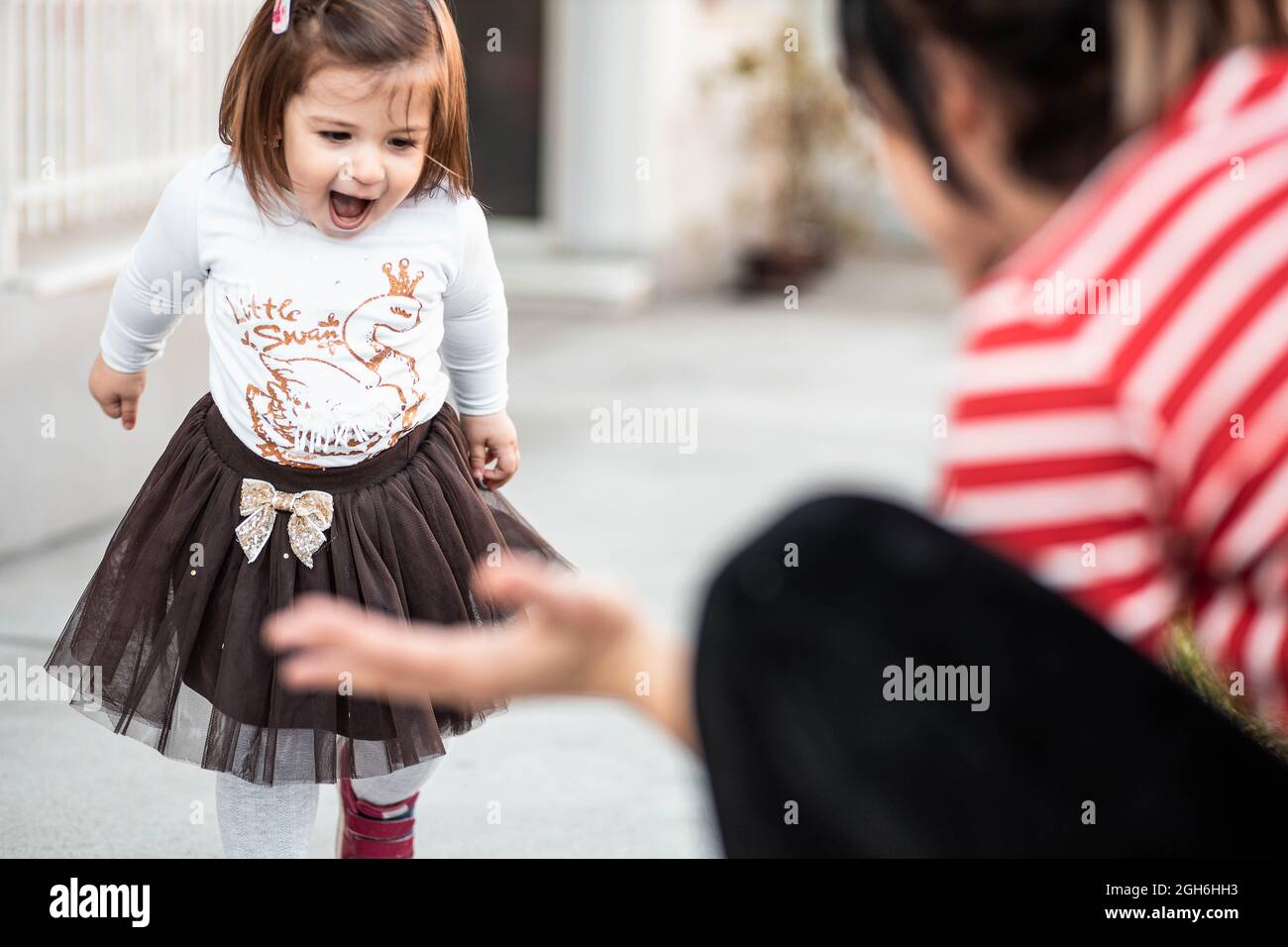 Cute, little toddler girl walking towards her mom Stock Photo