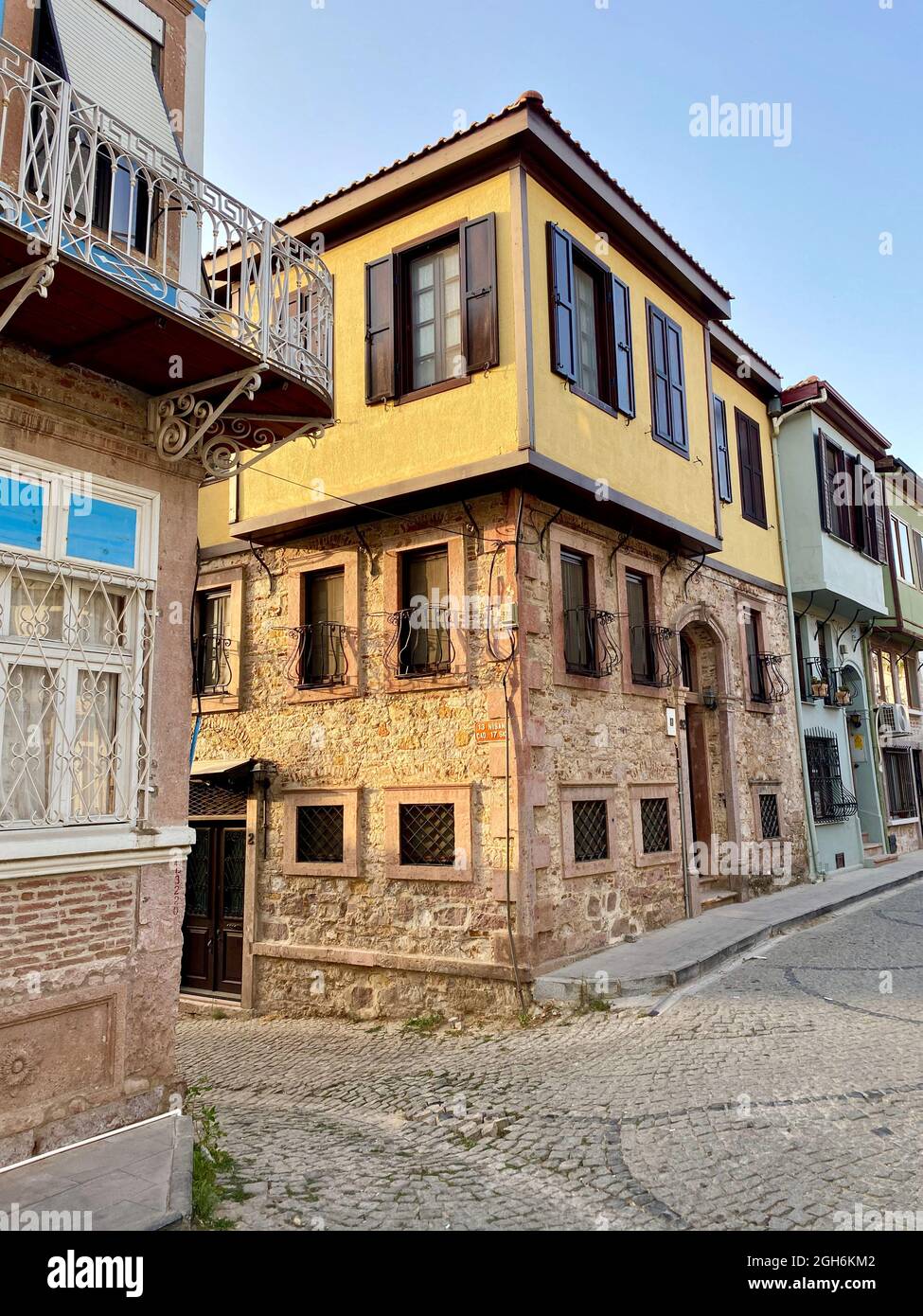 Old greek and Turkish Ottoman style houses in a narrow street of Ayvalik. Stock Photo
