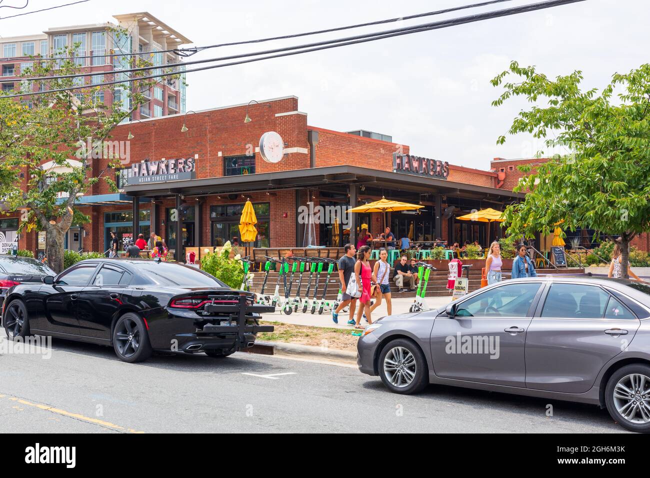 CHARLOTTE, NC, USA-25 JULY 2021: Hawkers Asian Street Fare in South end with people walking by and others dining on veranda. Stock Photo