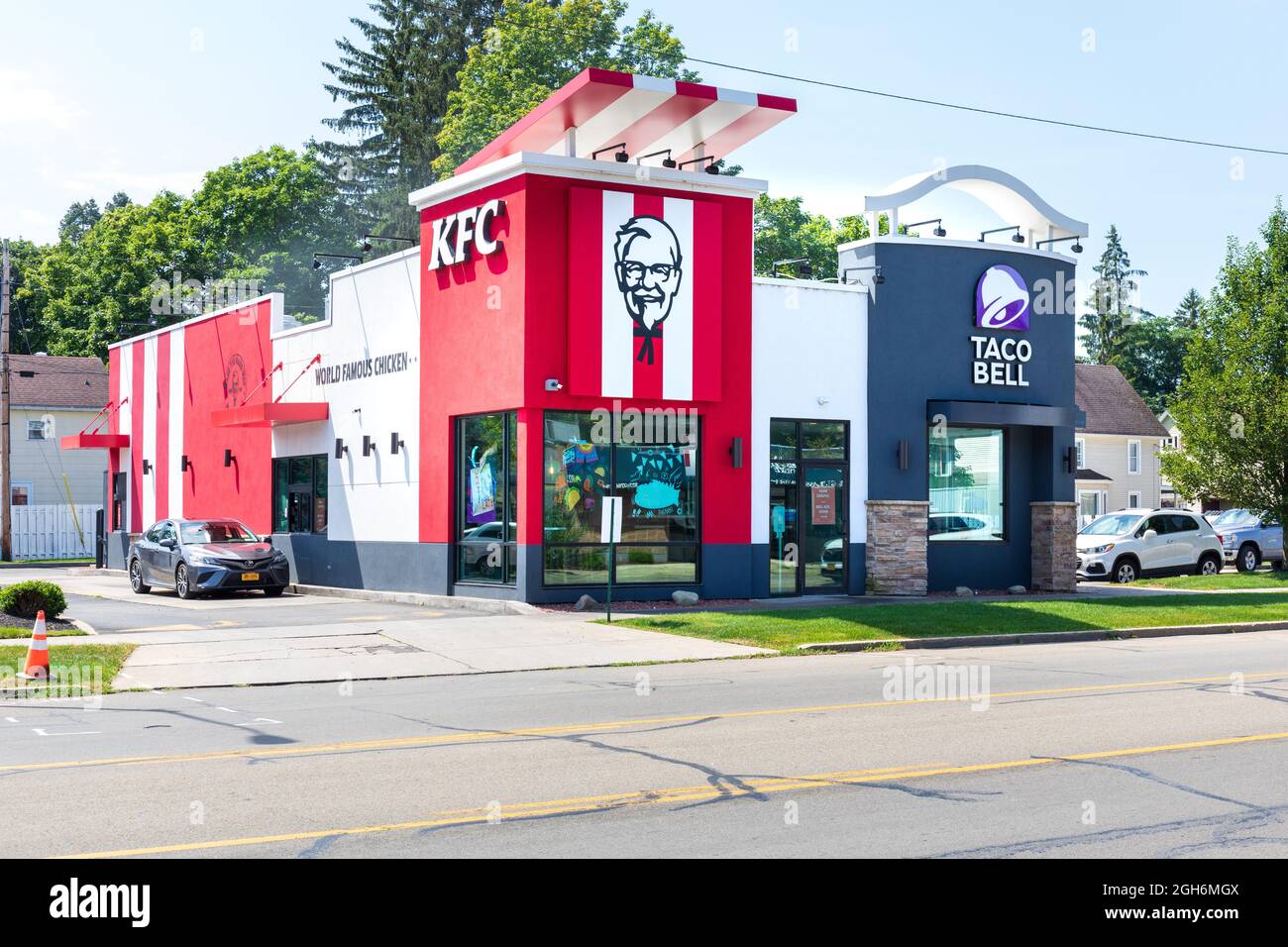 OLEAN, NY, USA-14 AUGUST 2021: A KFC and Taco Bell sharing a building in downtown. Shows building front and side drive thru. Stock Photo