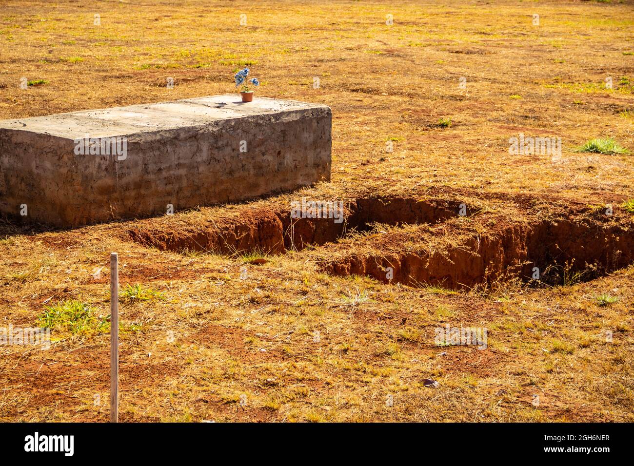 Details of open graves in a cemetery. Holes drilled in the ground for graves. Stock Photo