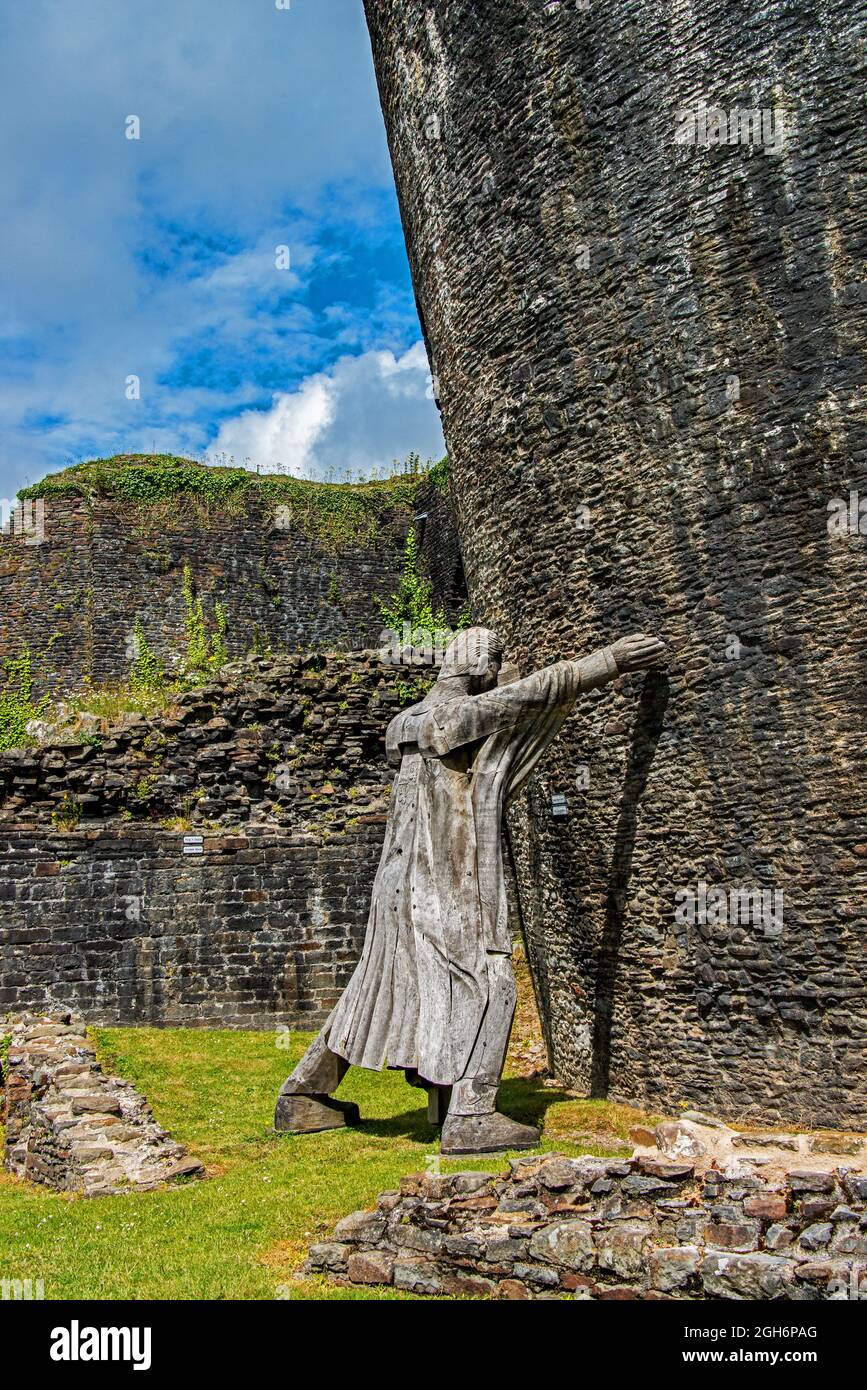 Model figure 'holding-up' the leaning tower of Caerphilly castle. Wales. UK Stock Photo