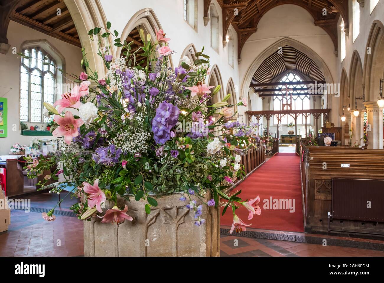 Flowers decorating the font of St Nicholas' church, Dersingham.  Part of the village's Open Gardens day. Stock Photo