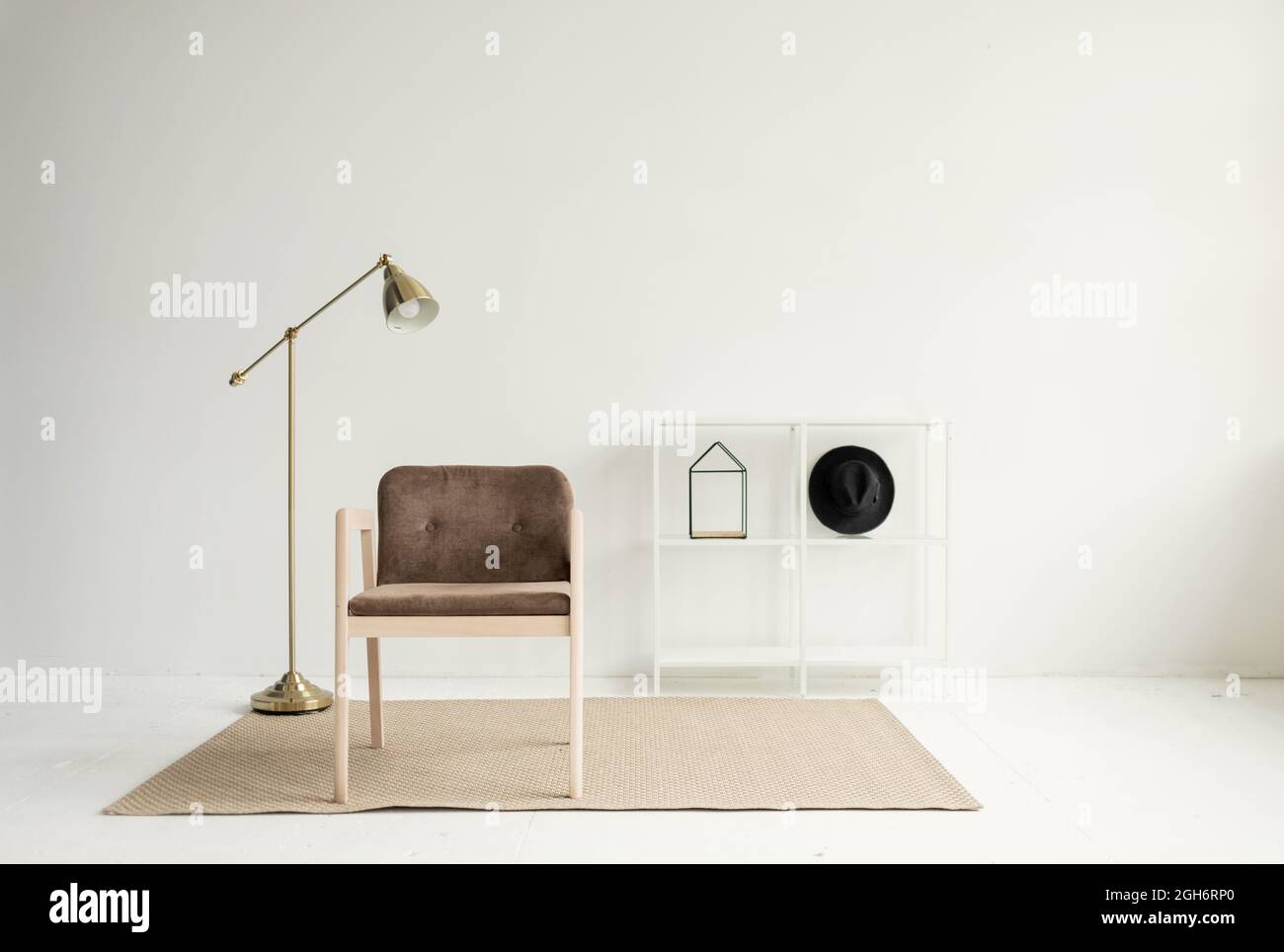 Modern armchair and lamp in a minimalist living room interior Stock ...