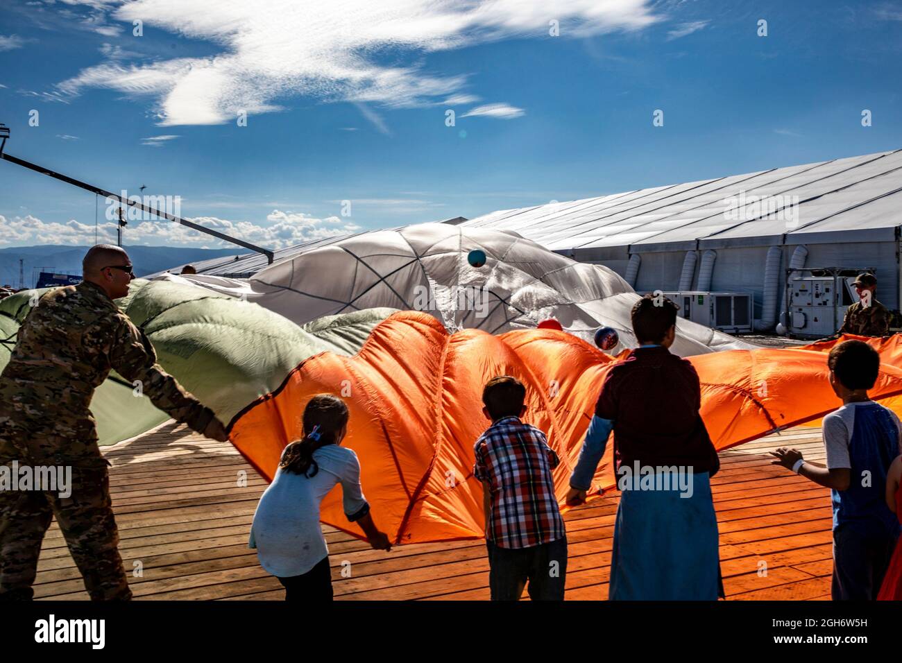U.S. Air Force airmen play the parachute game with young Afghan