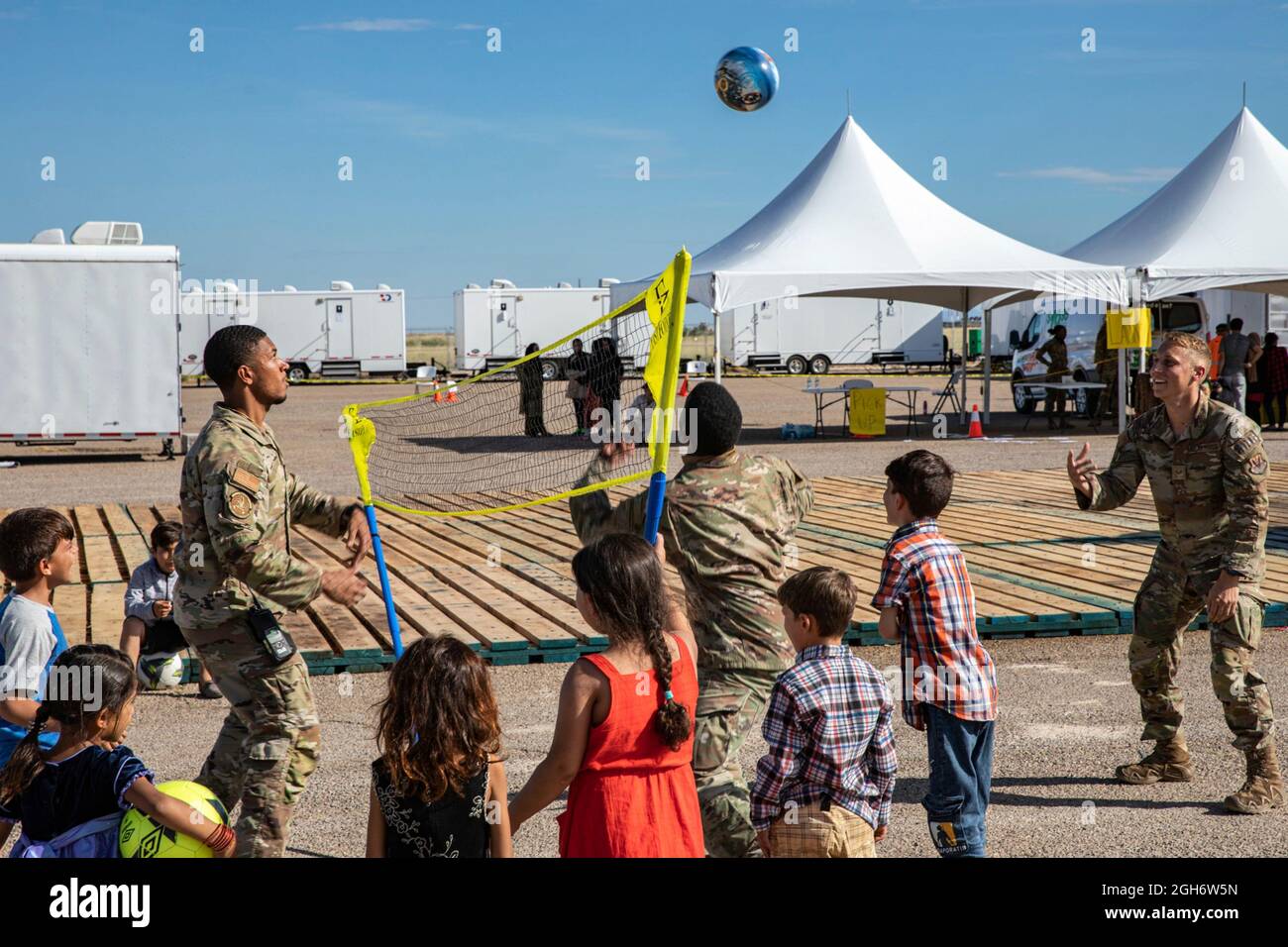 U.S. Air Force airmen play a game of volleyball with young Afghan refugees evacuated from Kabul during their stay at Holloman Air Force Base September 3, 2021 in Alamogordo, New Mexico. Holloman has created temporary housing for at least 50,000 Afghan evacuees. Stock Photo