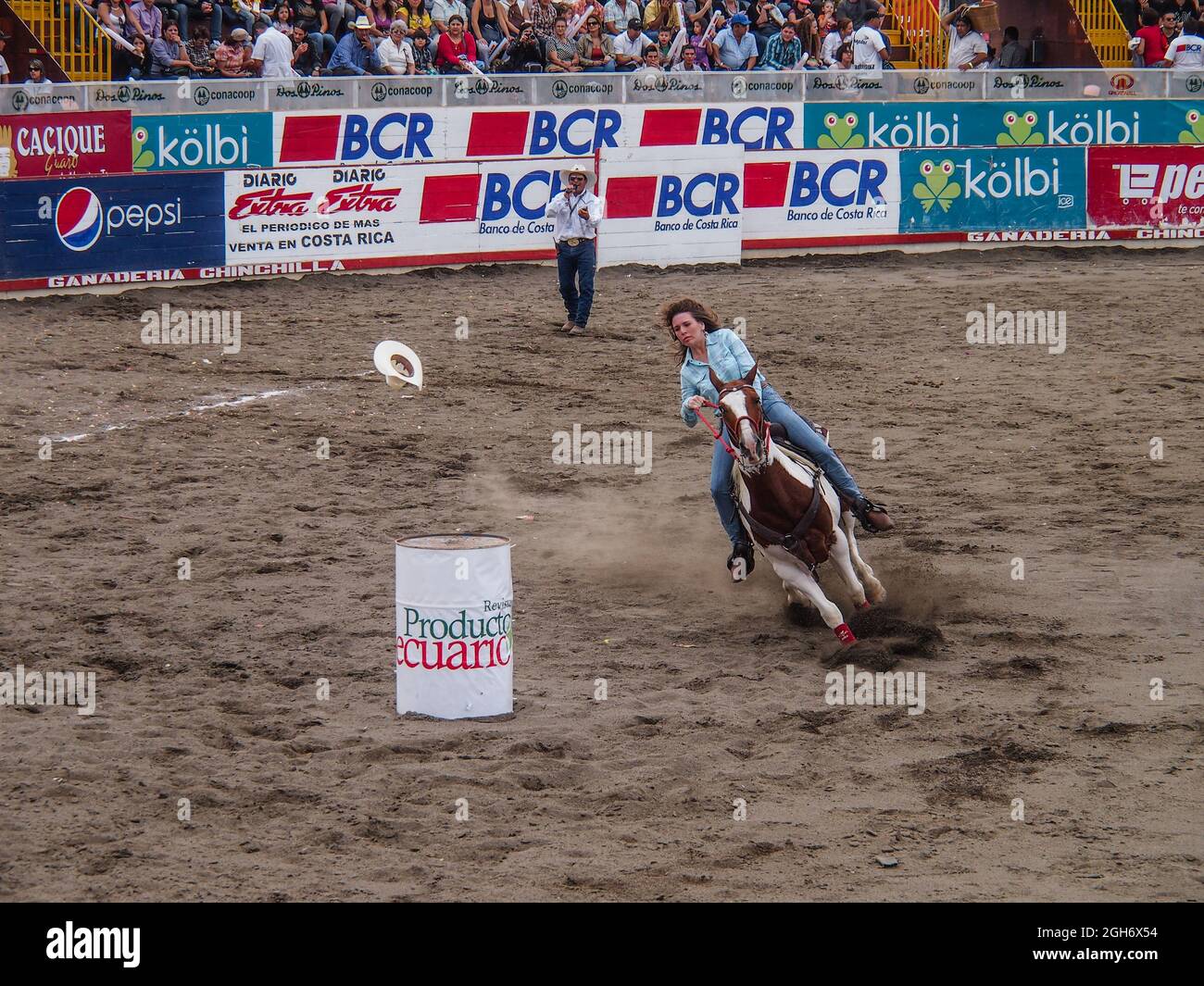 Costa Rica Rodeo Woman riding a horse in the barrel racing event at a rodeo in Costa ...
