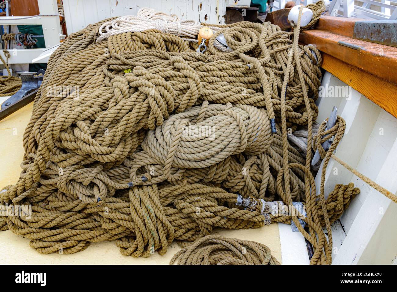 A pile of assorted heavy rope on the deck of a sailing ship. Rope is ...