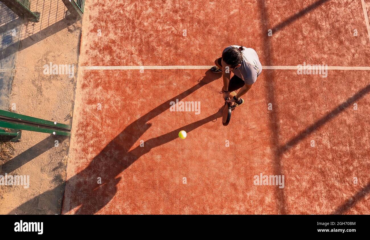 Top view of a paddle tennis player who is hitting the ball with the ...