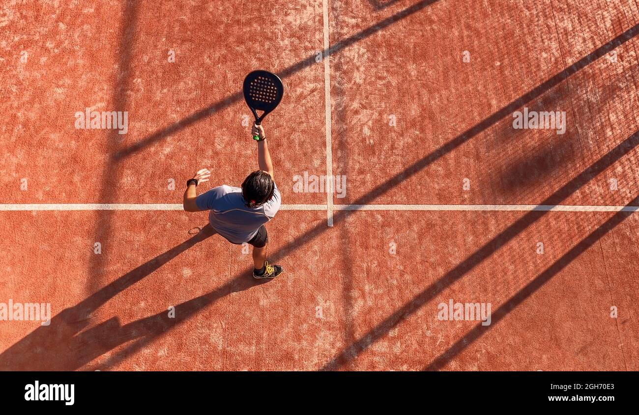 View from above of a man playing paddle tennis on an outdoor court ...