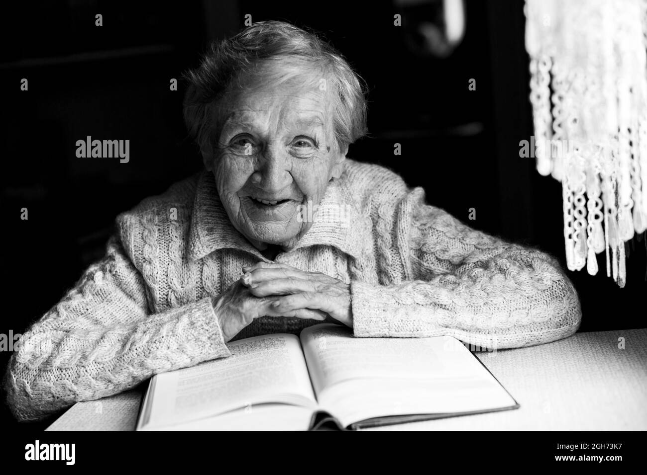 Portrait of an old woman reading a book. Black and white photo. Stock Photo