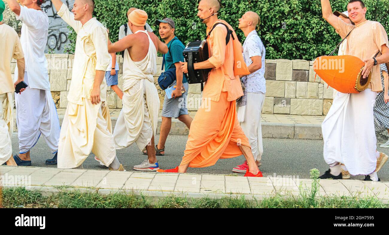 Hare Krishna singings march through the street Stock Photo