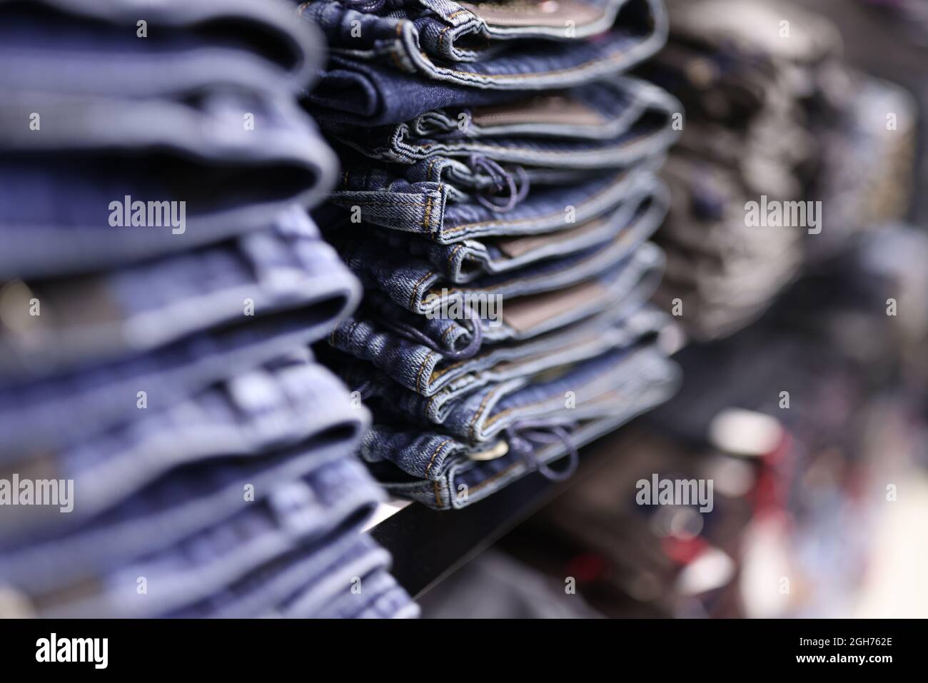 Stack of blue jeans in different shades at store closeup Stock Photo
